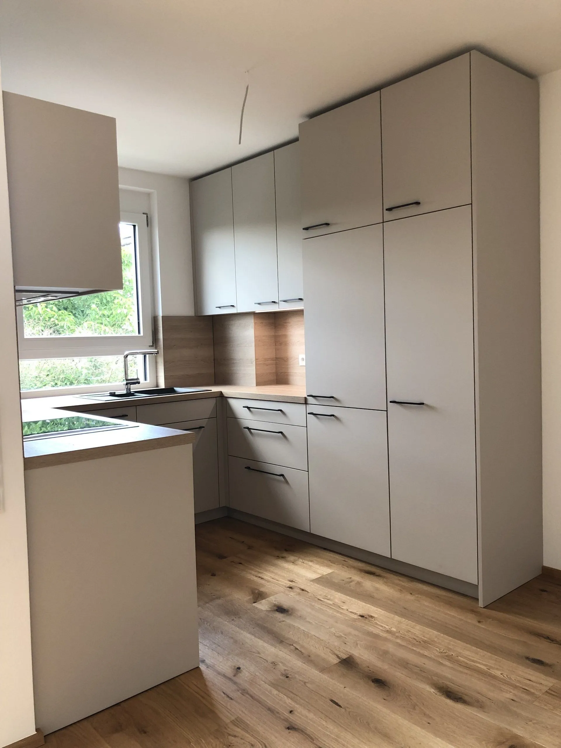 Helle Einbauküche mit Holzboden
