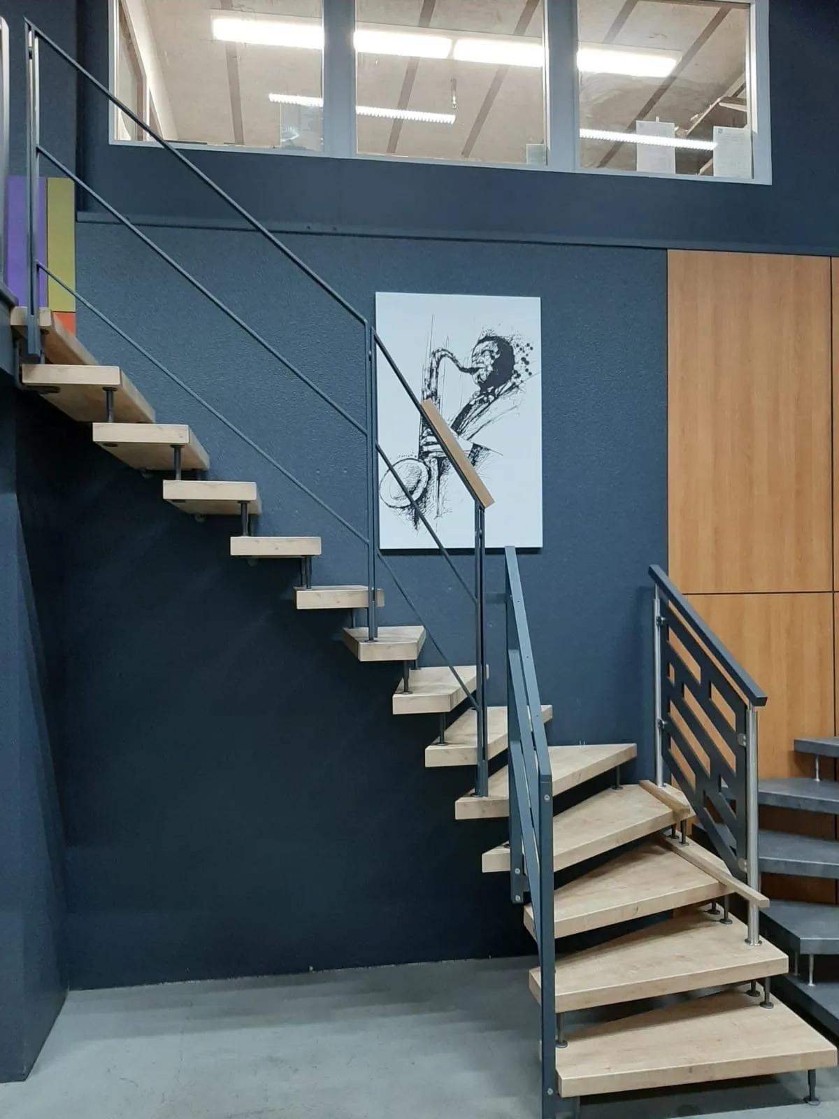 Freischwebende Holztreppe an blauer Wand